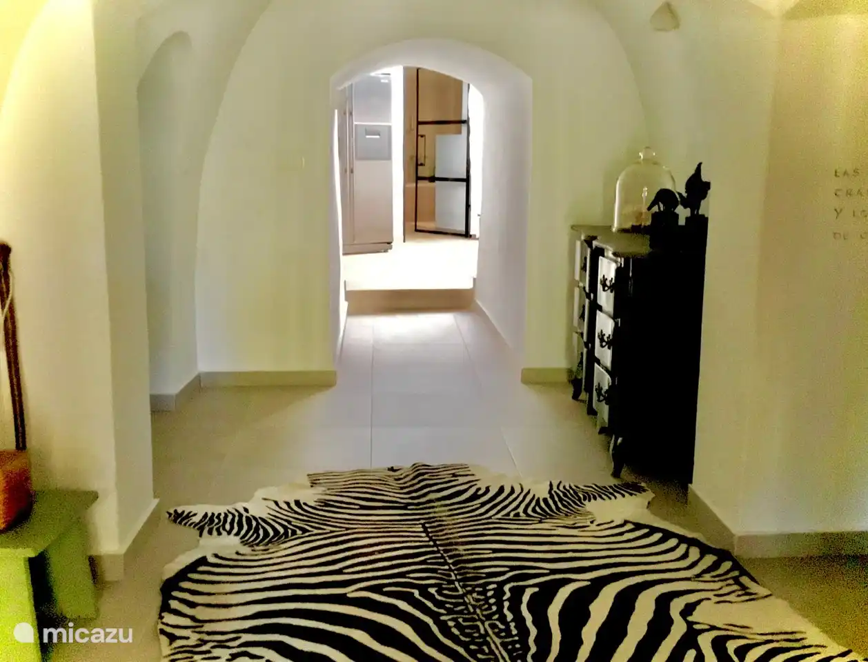 Accès depuis le séjour à la maison troglodyte où se trouvent la cuisine, trois chambres et 2 salles de bain ainsi qu'un coin salon