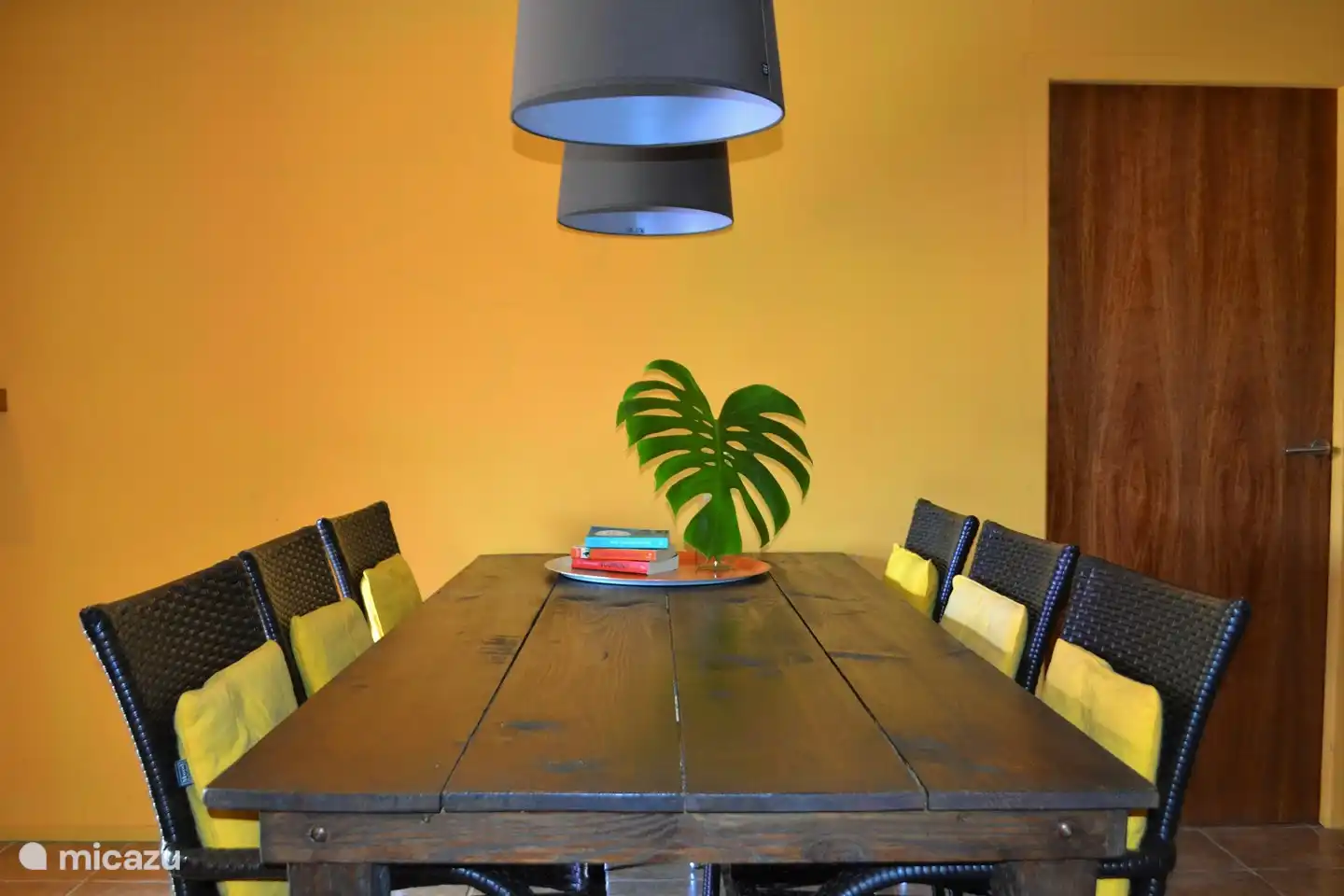 Sala de estar con cocina abierta, gran mesa de comedor, cómodo sofá lounge y TV por Internet.