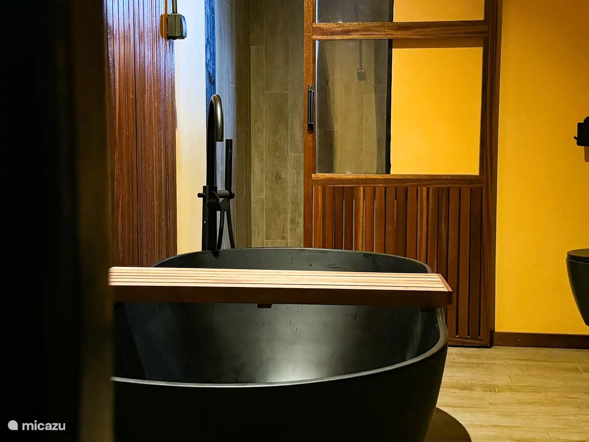 Cuarto de baño independiente con ducha de lluvia, bañera, inodoro y lavabo doble.