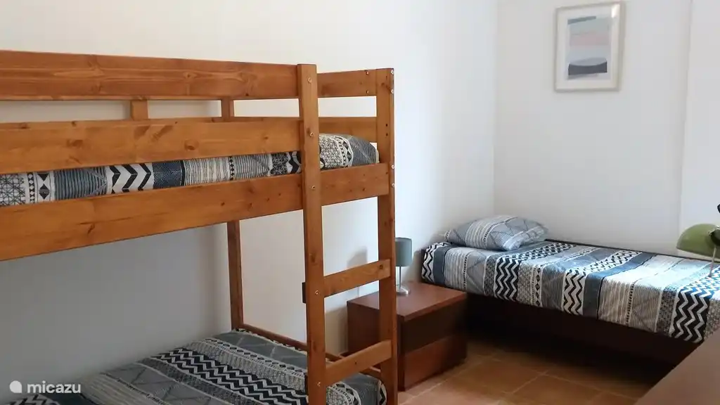 slaapkamer met 1 persoonbed en stapelbed. Badkamer direct er naast 