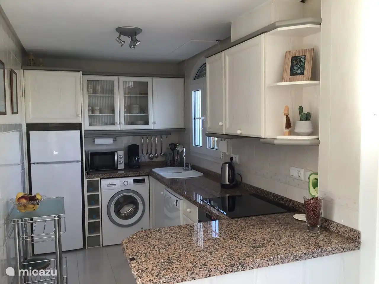 De volledig ingerichte keuken met vaatwasser en wasmachine.