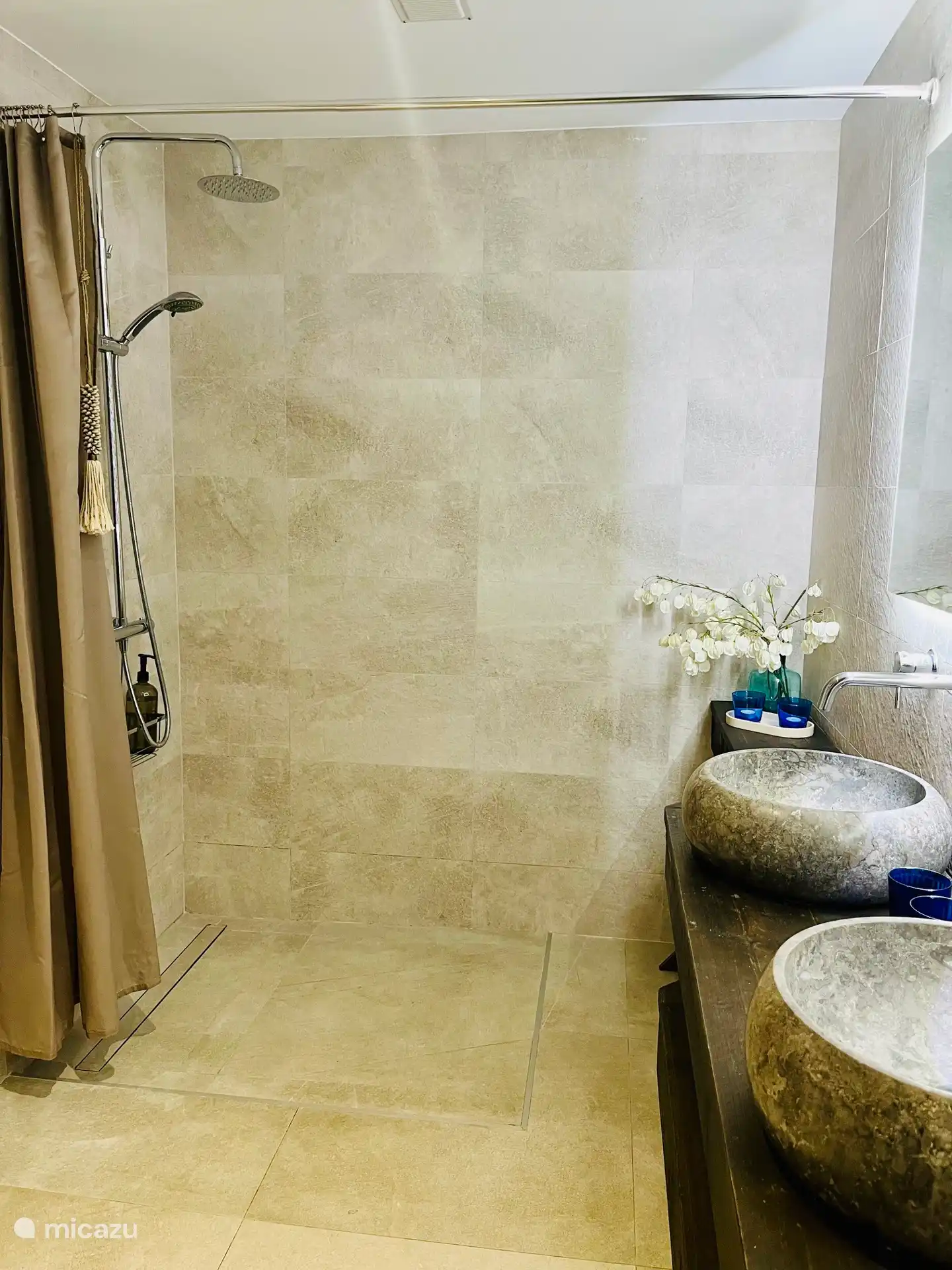 Salle de bain principale avec douche à italatoïde intégrée, double lavabo, toilettes, espace de rangement. 