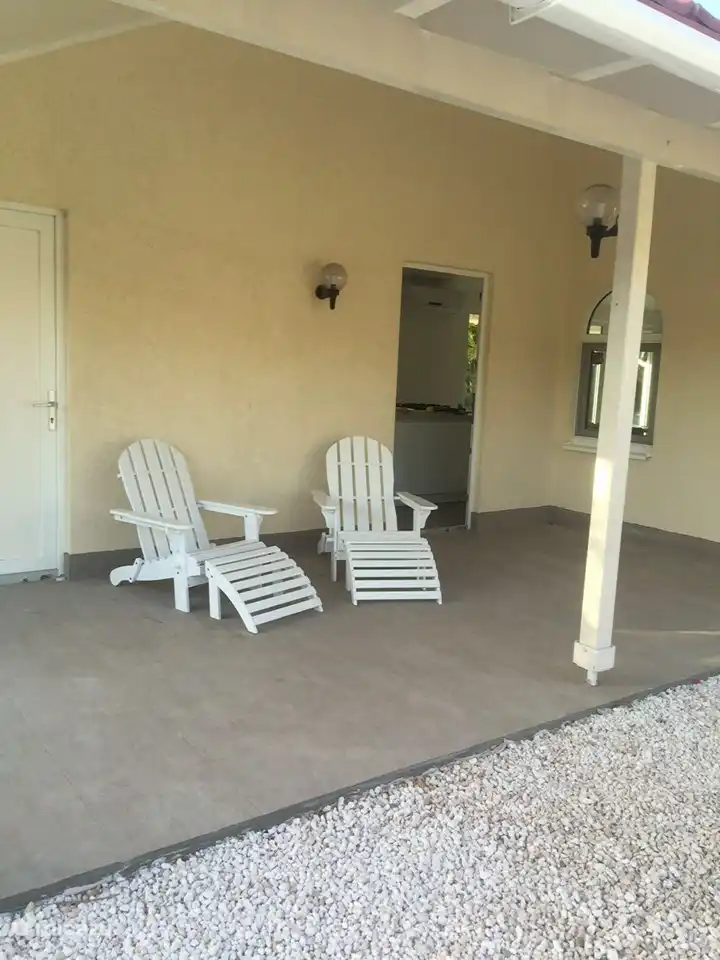 Vorderseite der Villa und Seiteneingang mit 2 schönen Stühlen. Ideal zum Entspannen am Morgen. 