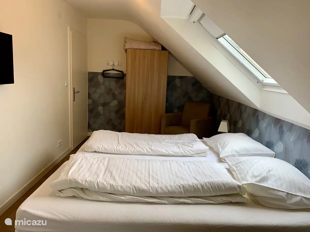 dormitorio con dos sommiers separados y TV