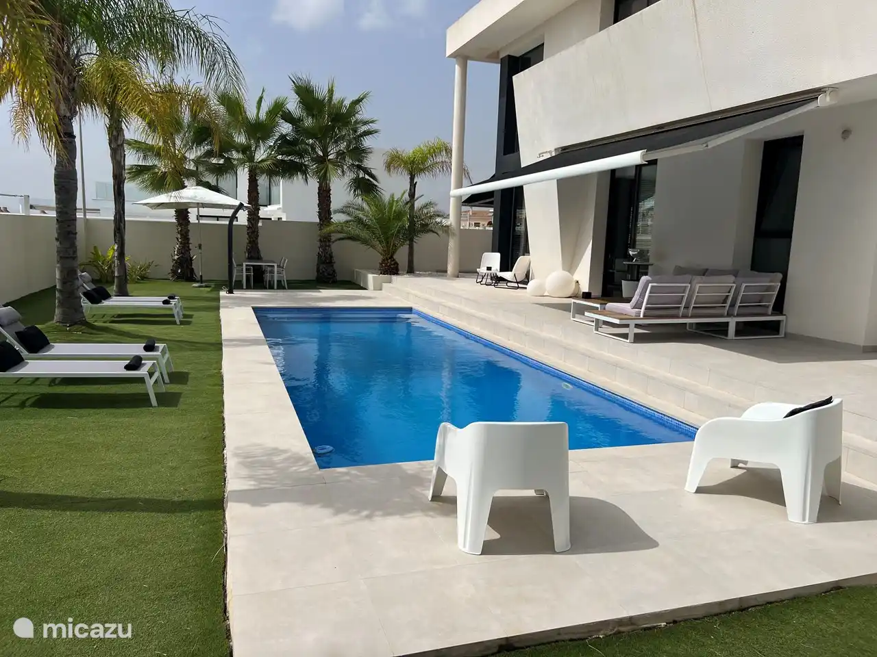 Rückseite des Hauses mit großem Garten und einer Sonnenterrasse und einem großen Swimmingpool