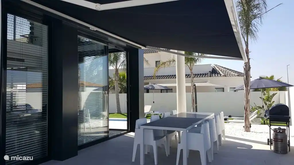 Außenterrasse mit 8 Personen Essbereich mit Gasgrill unter elektrischem Sonnenschirm von 6 Metern im Schatten