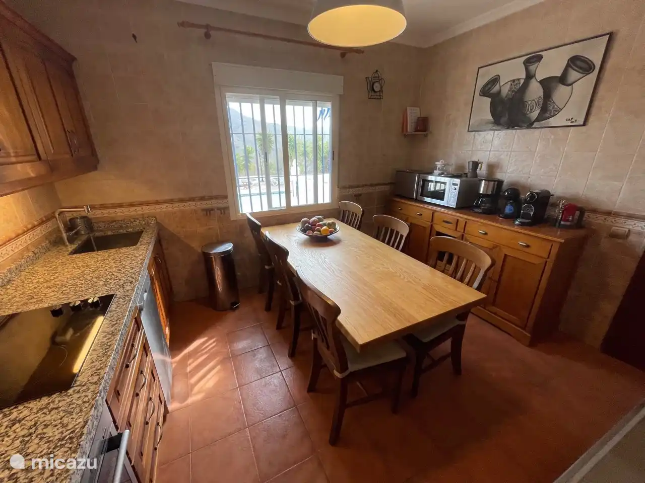 Cocina con panificadora, microondas, batidora y varias cafeteras.