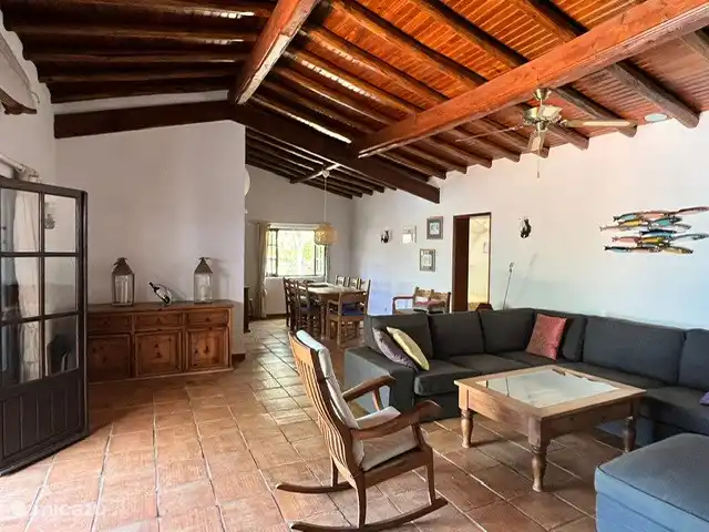 Maison d'Urzé | Portugal, Algarve, Alcantarilha - villa Salon avec grand canapé d'angle, chaise berçante et portes-fenêtres donnant sur le jardin.
