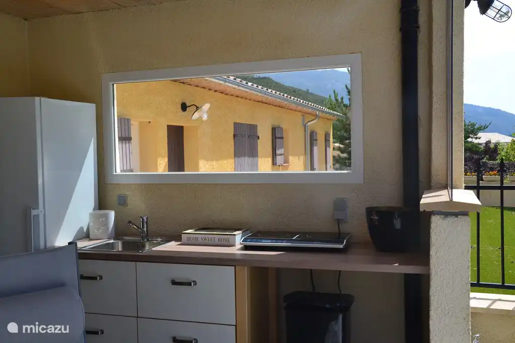 La cuisine extérieure couverte avec réfrigérateur/congélateur, évier avec eau froide/chaude, plaque d'achat (induction)