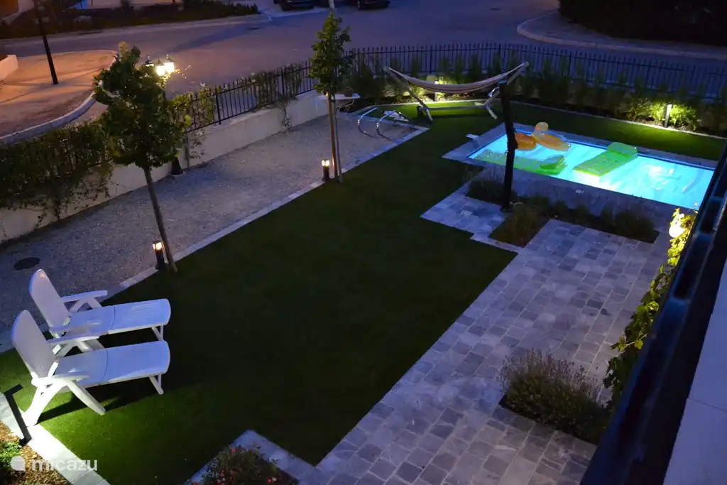 Photo du jardin la nuit, prise depuis la spacieuse terrasse sur le toit.