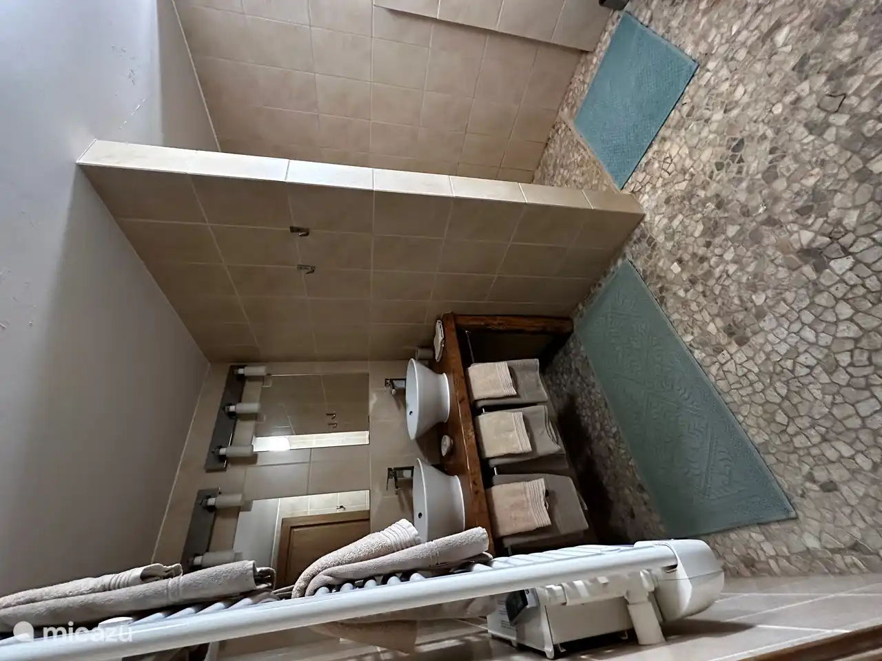 Badezimmer mit Dusche, zwei Waschbecken und einer Toilette