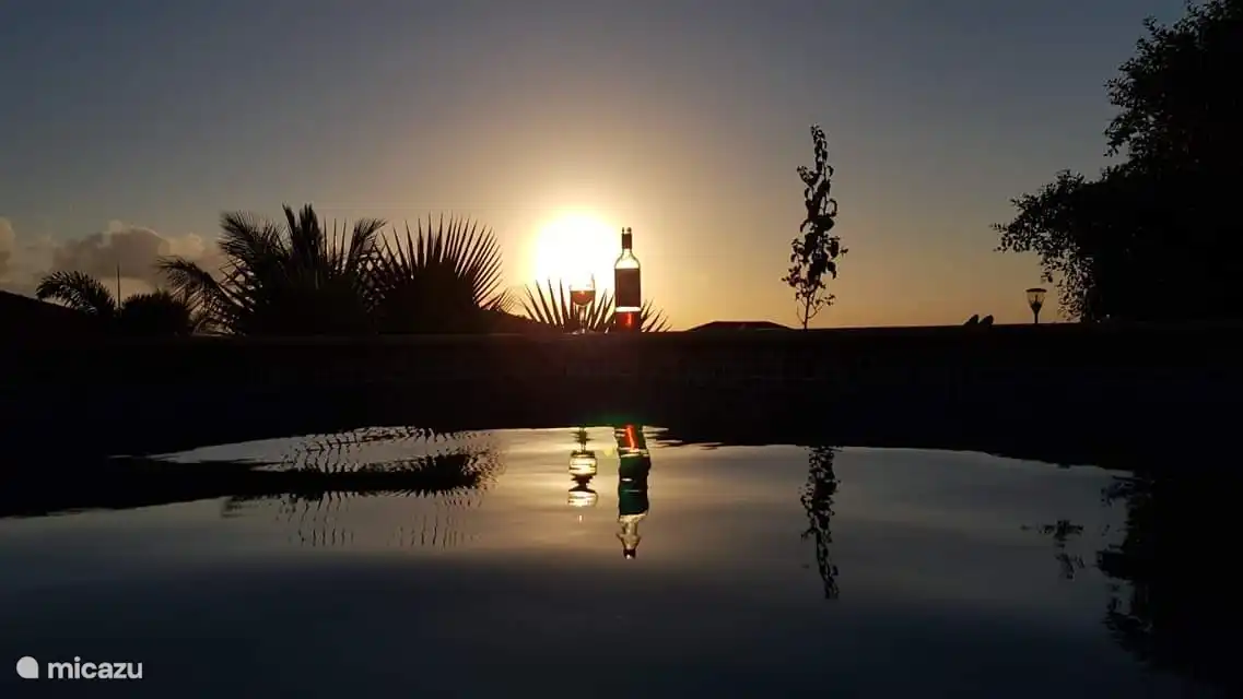 Sonnenuntergang am Pool mit einem kühlen Glas Wein.