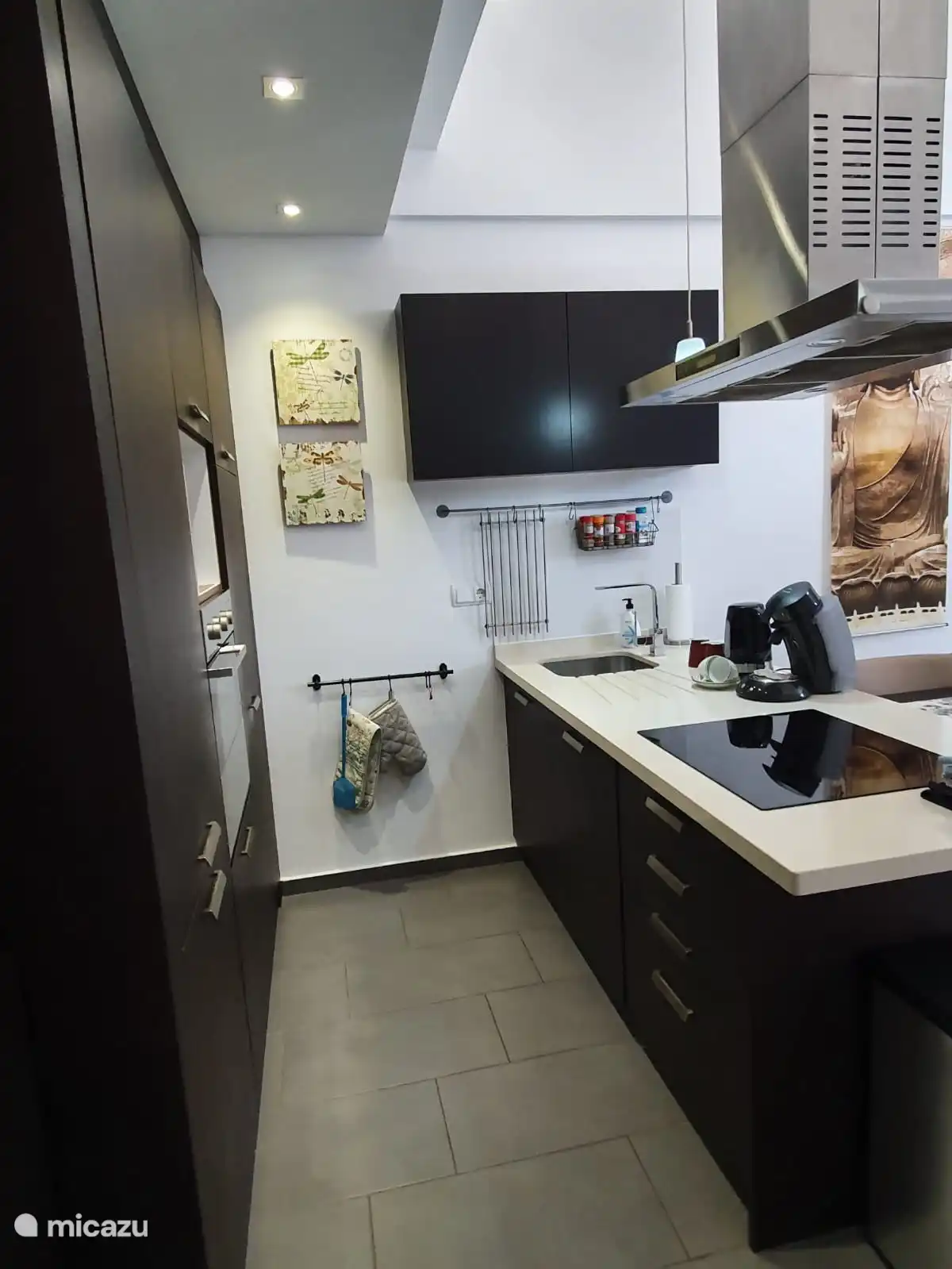 Moderne Küche mit Geschirrspüler, Mikrowelle, Backofen, Kühlschrank mit Gefrierfach.