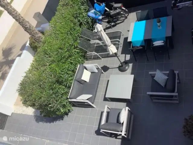 casa vacacional en España, Costa Blanca, Orihuela Costa – Golfo y Mar La terraza de la planta baja con sillas, tumbonas, sombrilla y mesa de comedor