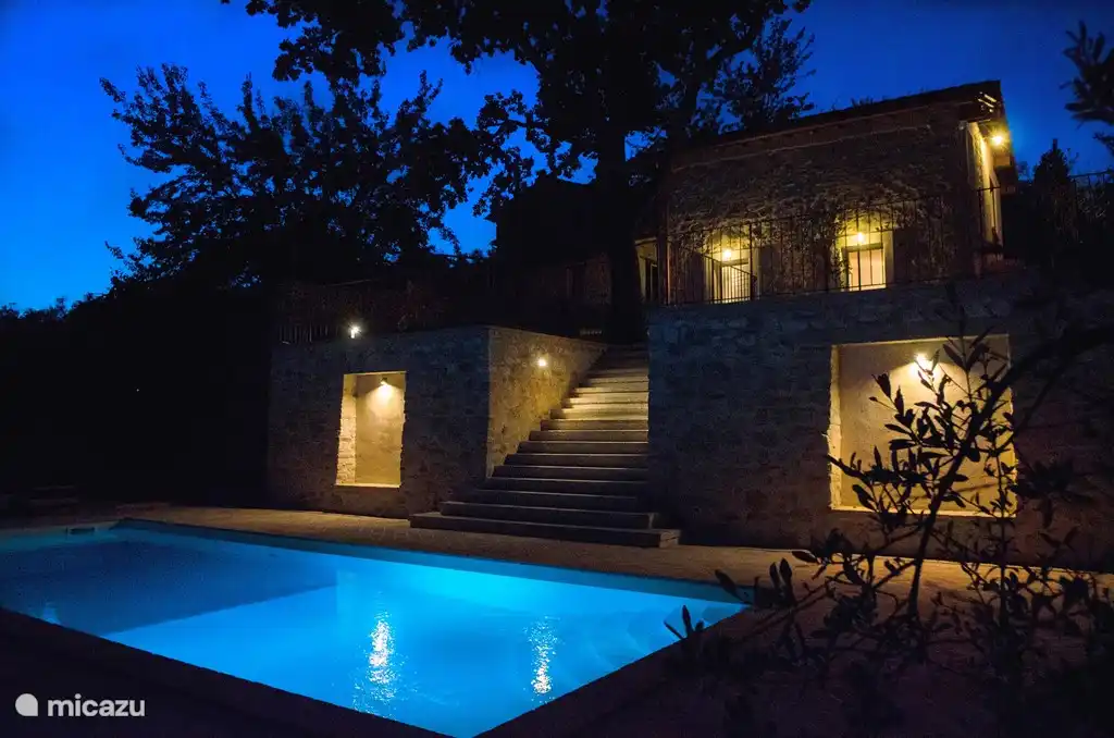 Piscina al anochecer, con el estudio al fondo