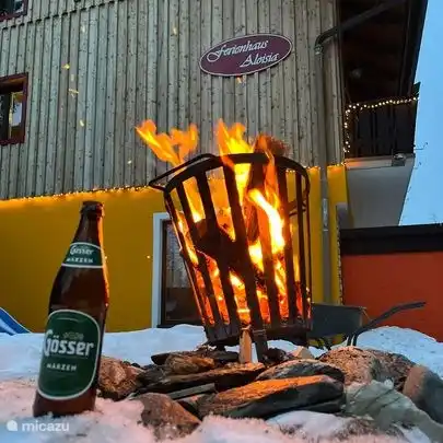 Tuin met vuurkorf, grill en speeltoestellen.