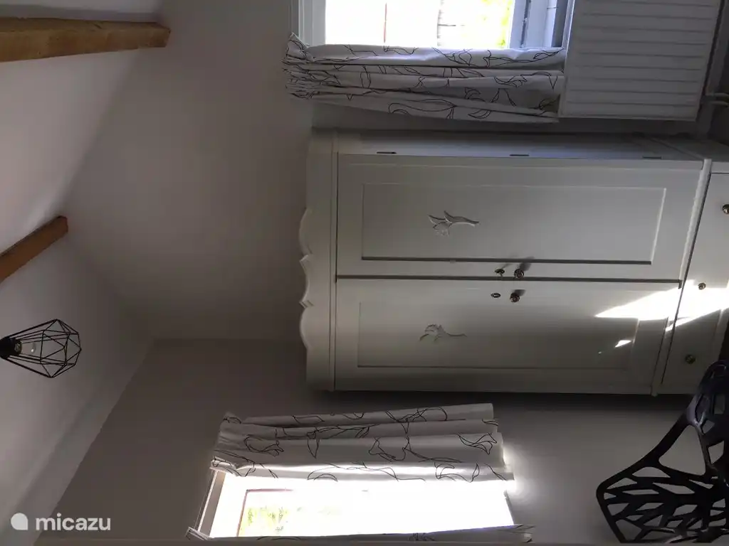 De twee slaapkamers boven hebben een hoge nok en zijn in moderne stijl ingericht.  