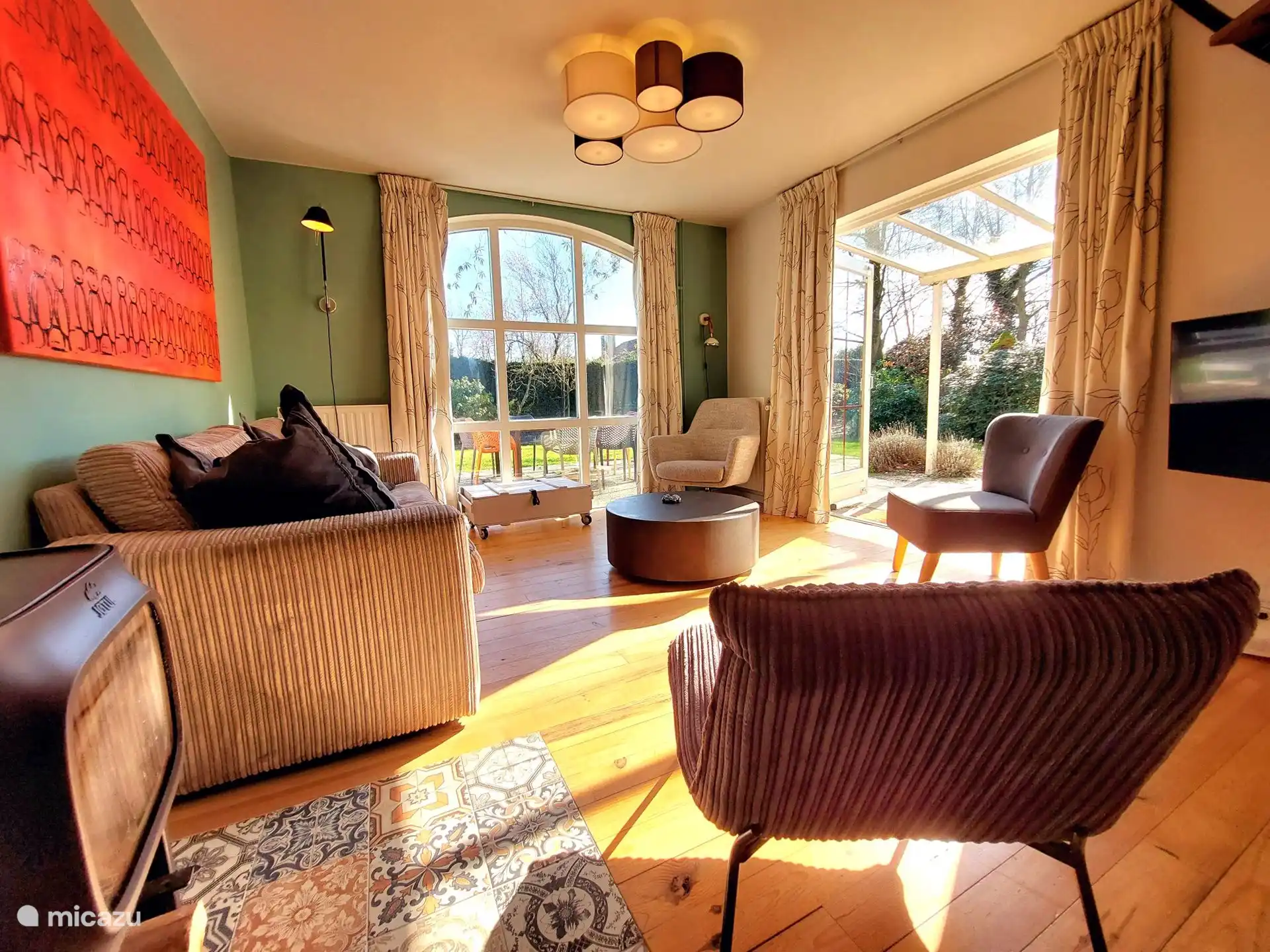 Een lichte zitkamer met zicht op de tuin. 