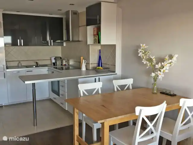 Location de Vacances Espagne, Costa Brava, Sant Feliu de Guíxols, appartement - Caleta del Sol Sant Feliu de Guixols Séjour avec table à manger et la cuisine ouverte avec lave-vaisselle, réfrigérateur, congélateur, plaque de cuisson, four et machine à café Nespresso.