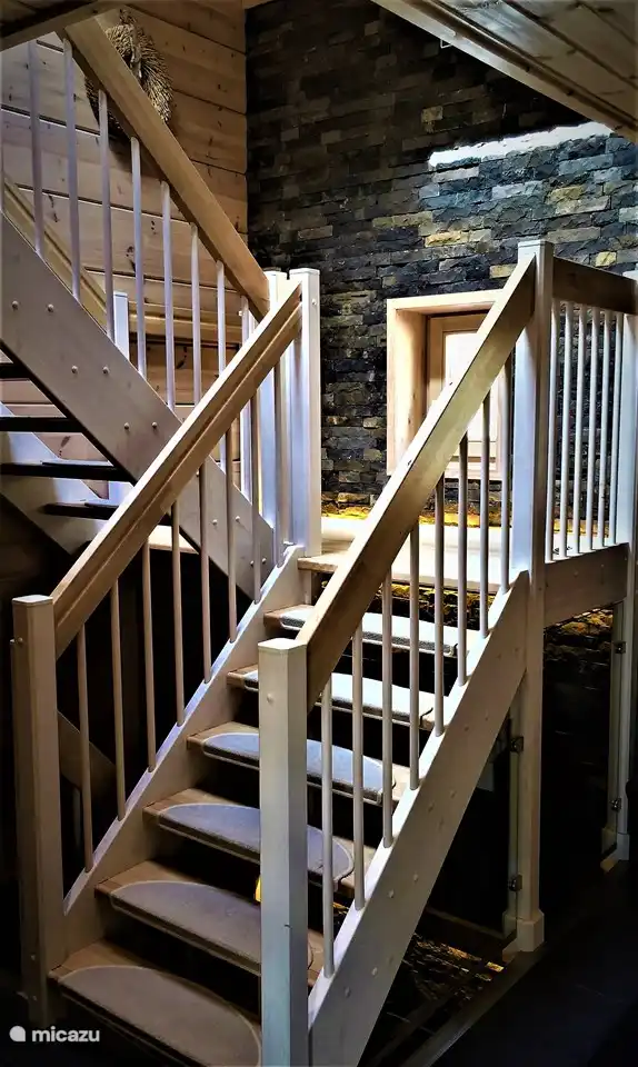 Das gemütliche Treppenhaus, das vom Wellness-Erdgeschoss über das Erdgeschoss zu den Schlafplätzen im 1. Stock führt.