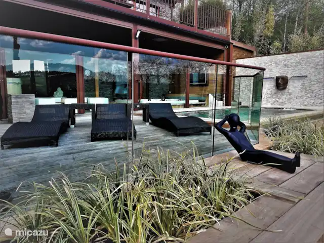 Wellness Chalet ROOS in Durbuy | Belgique, Ardennes, Bomal-sur-Ourthe - villa La piscine, les grandes chaises longues et l’espace bien-être intérieur derrière.