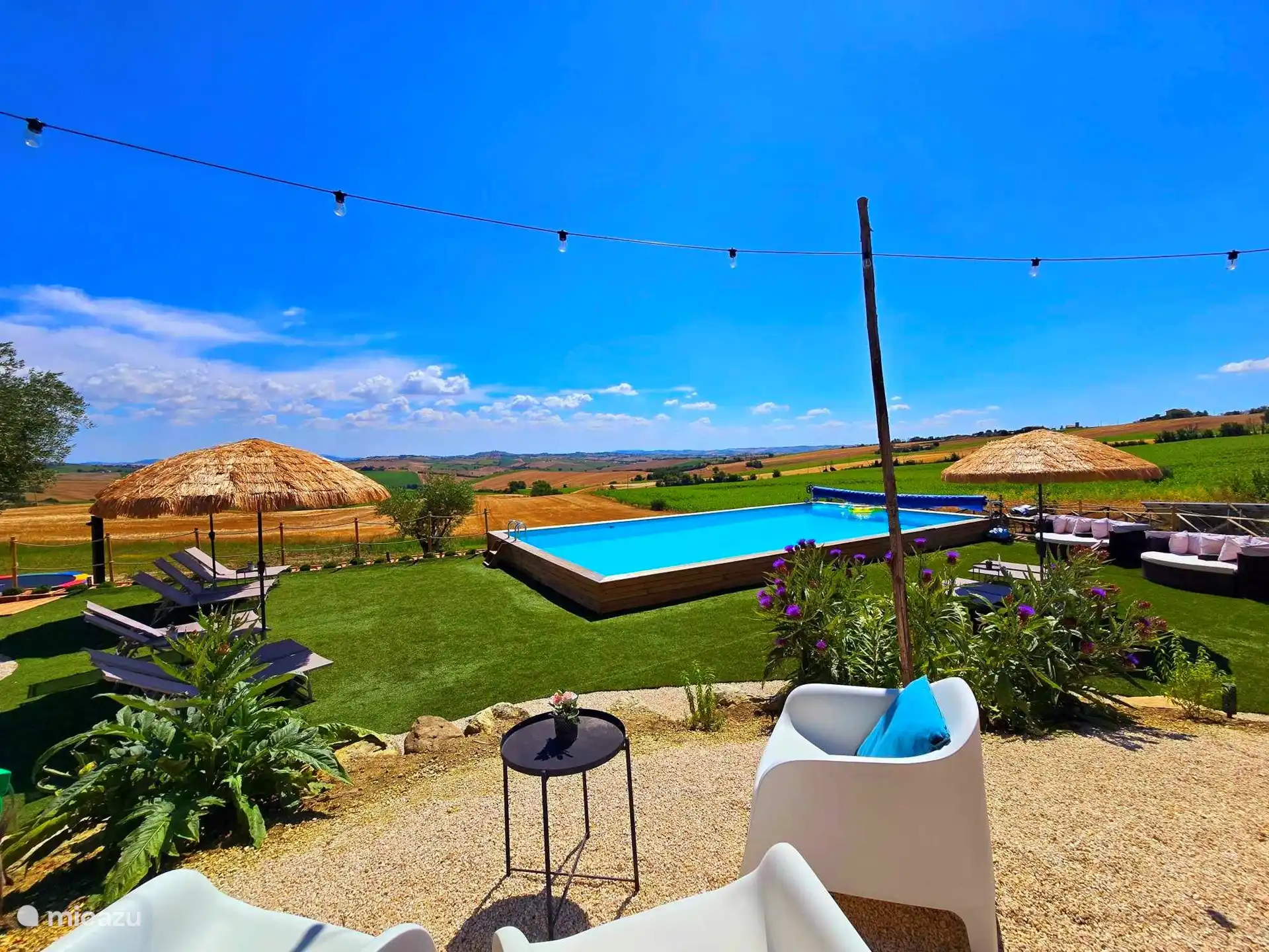 Piscina con tumbonas, tumbonas, sombrillas y una vista increíble