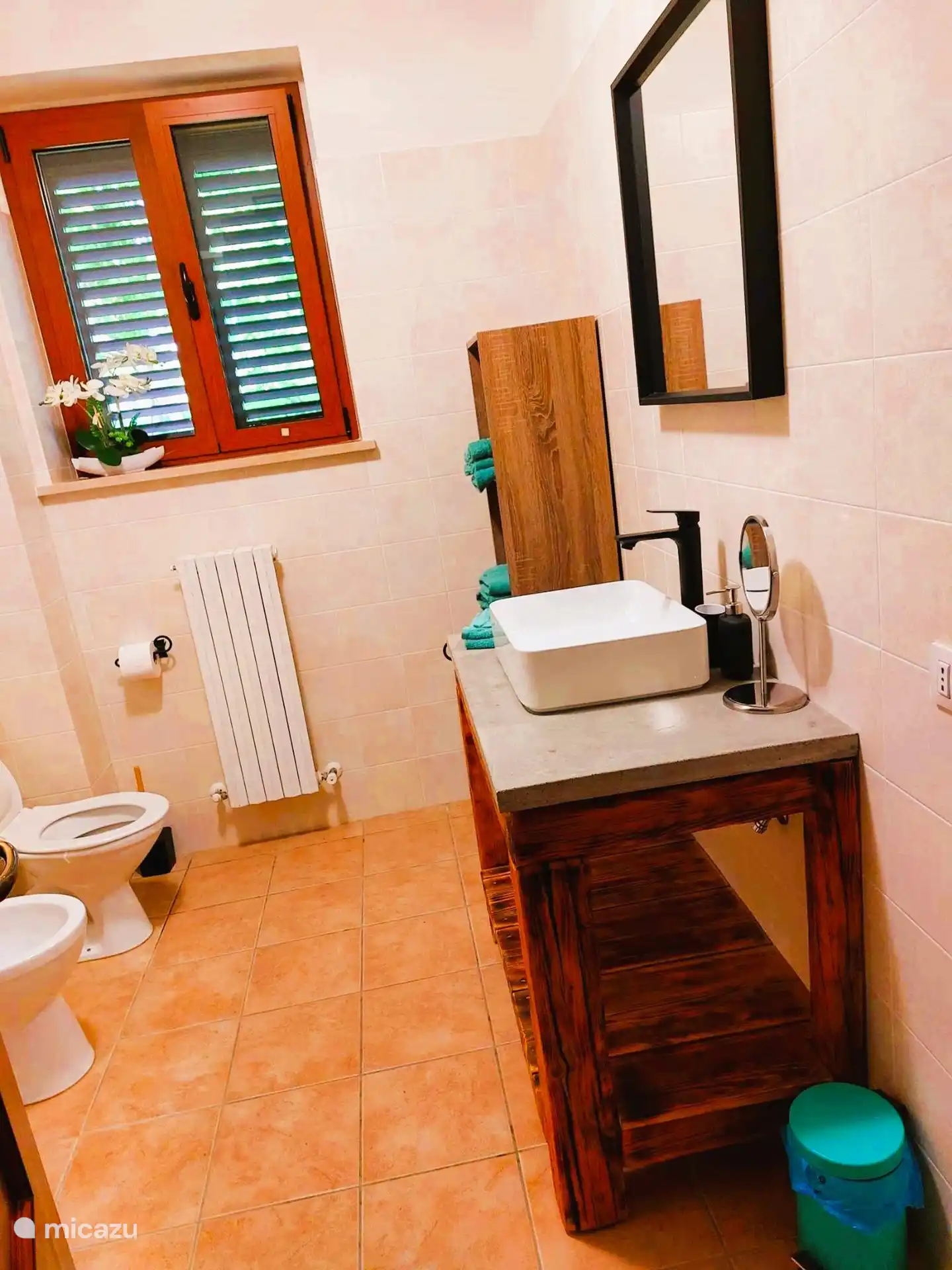 Amplio cuarto de baño con inodoro, lavabo, lavadora y ducha