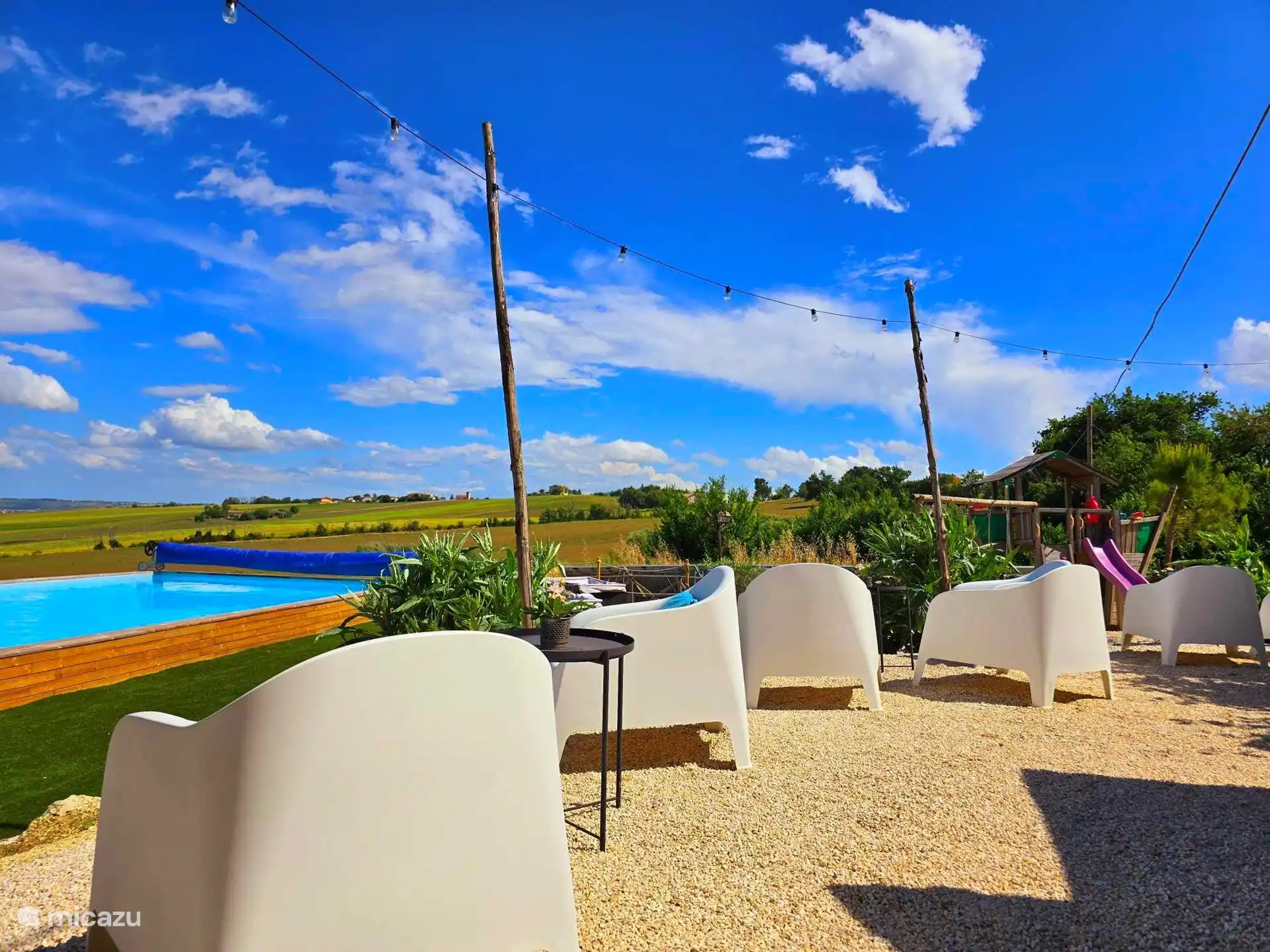 Zona de estar con vistas a la piscina y al barco de juegos