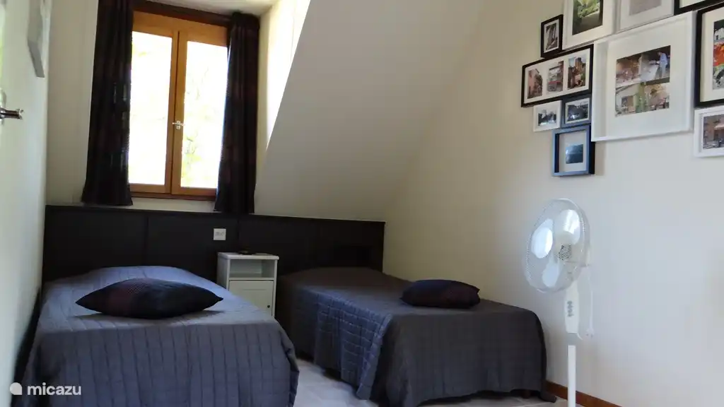 Zweites Schlafzimmer im Obergeschoss mit einem großen Kleiderschrank und einem Schreibtisch mit Stuhl auf der anderen Straßenseite