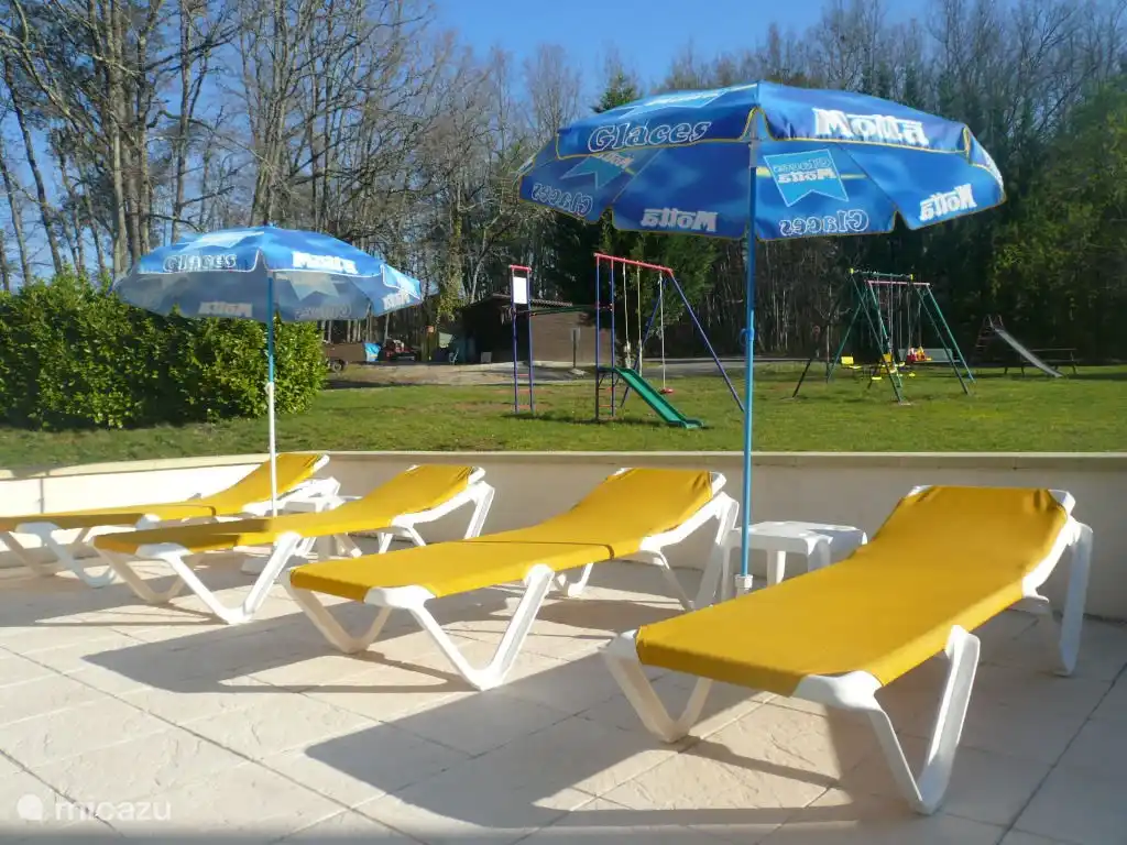 Terrasse mit Liegestühlen mit Blick auf Spielplatz