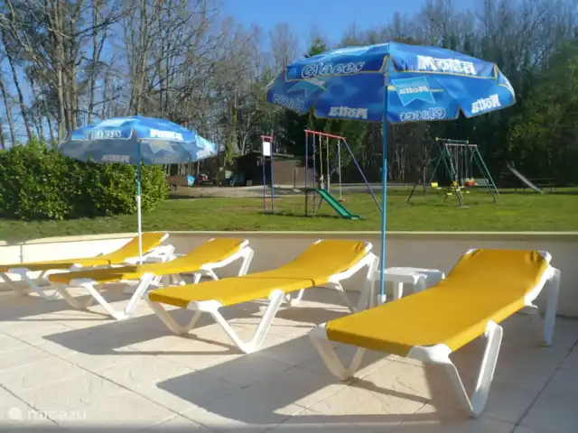 Location de Vacances France, Dordogne, Carlux, gîte / cottage - églantine A côté de la maison se trouve une terrasse avec des chaises longues et une vue sur l'aire de jeux. Toute la terrasse est carrelée.