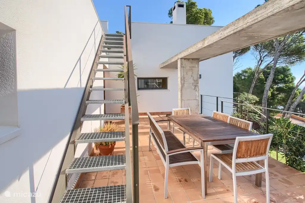 Terrasse mit Sitzgelegenheiten und Treppe zur Dachterrasse