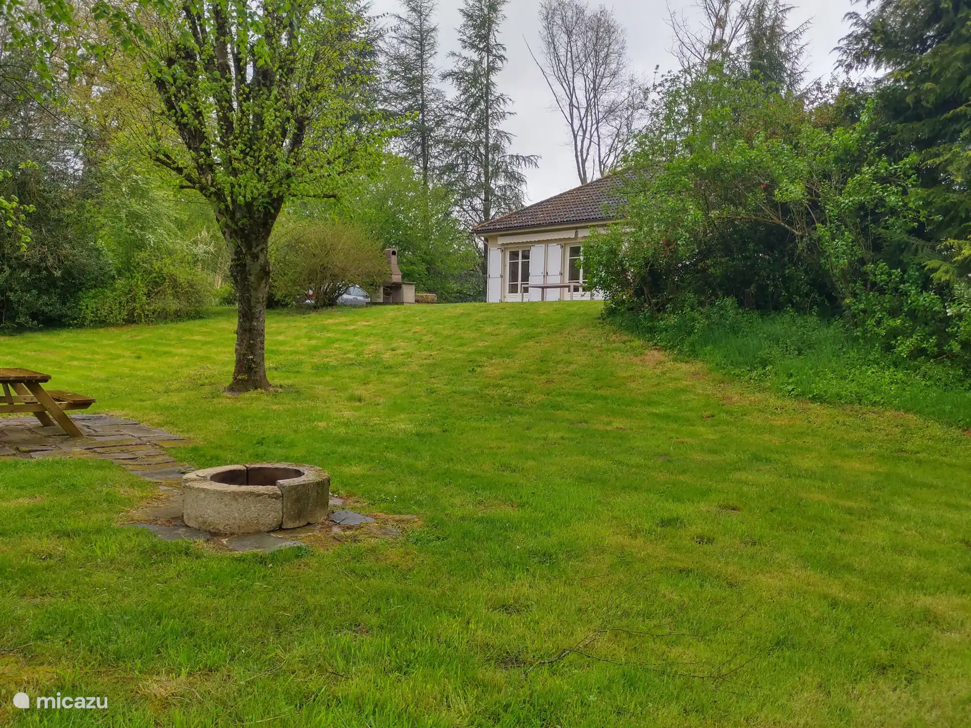 Détendez-vous sur la terrasse ensoleillée donnant sur le jardin verdoyant et le doux murmure de la rivière en arrière-plan.