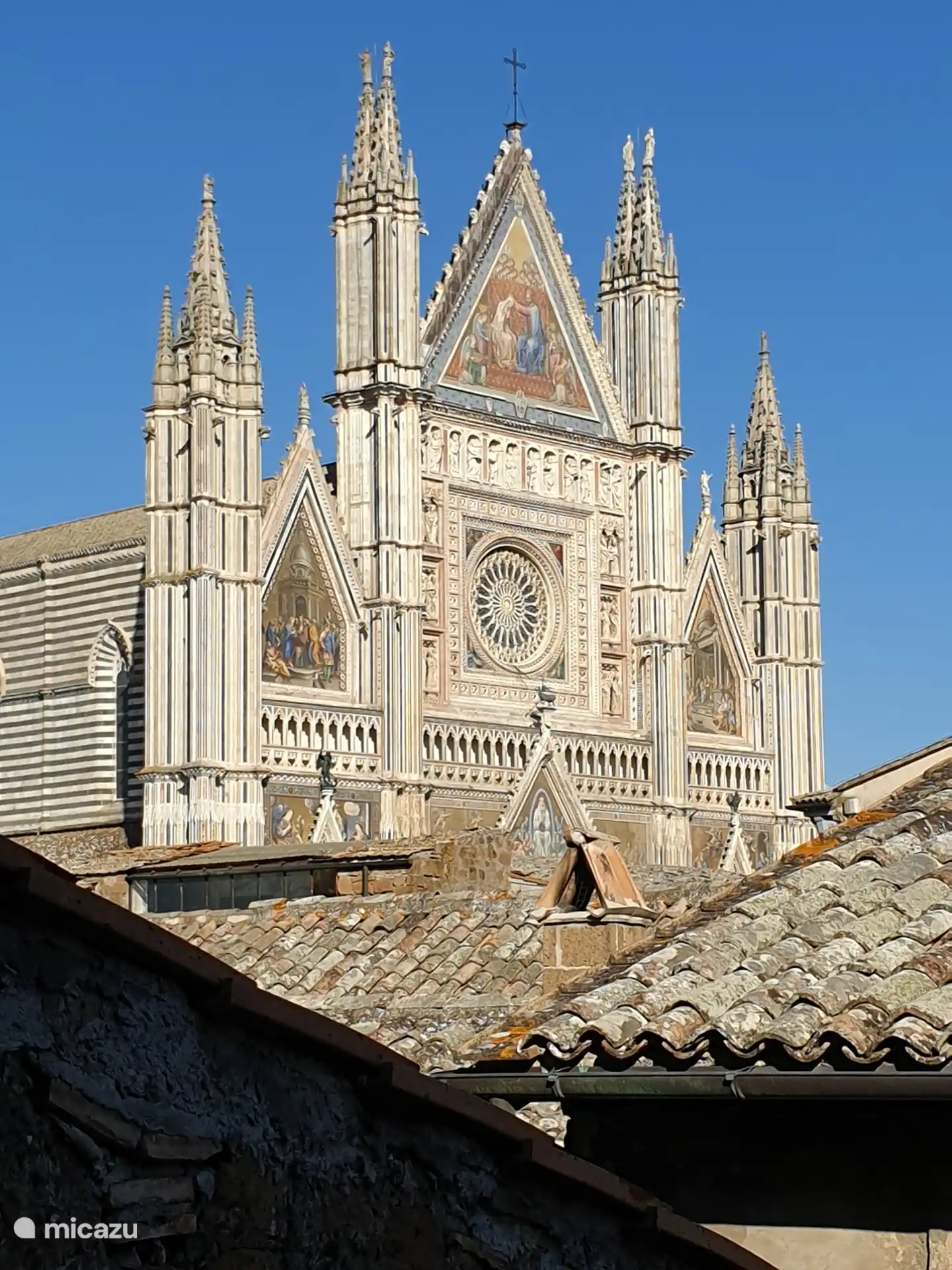 Fassade der Kathedrale von Orvieto mit Häuserdächern