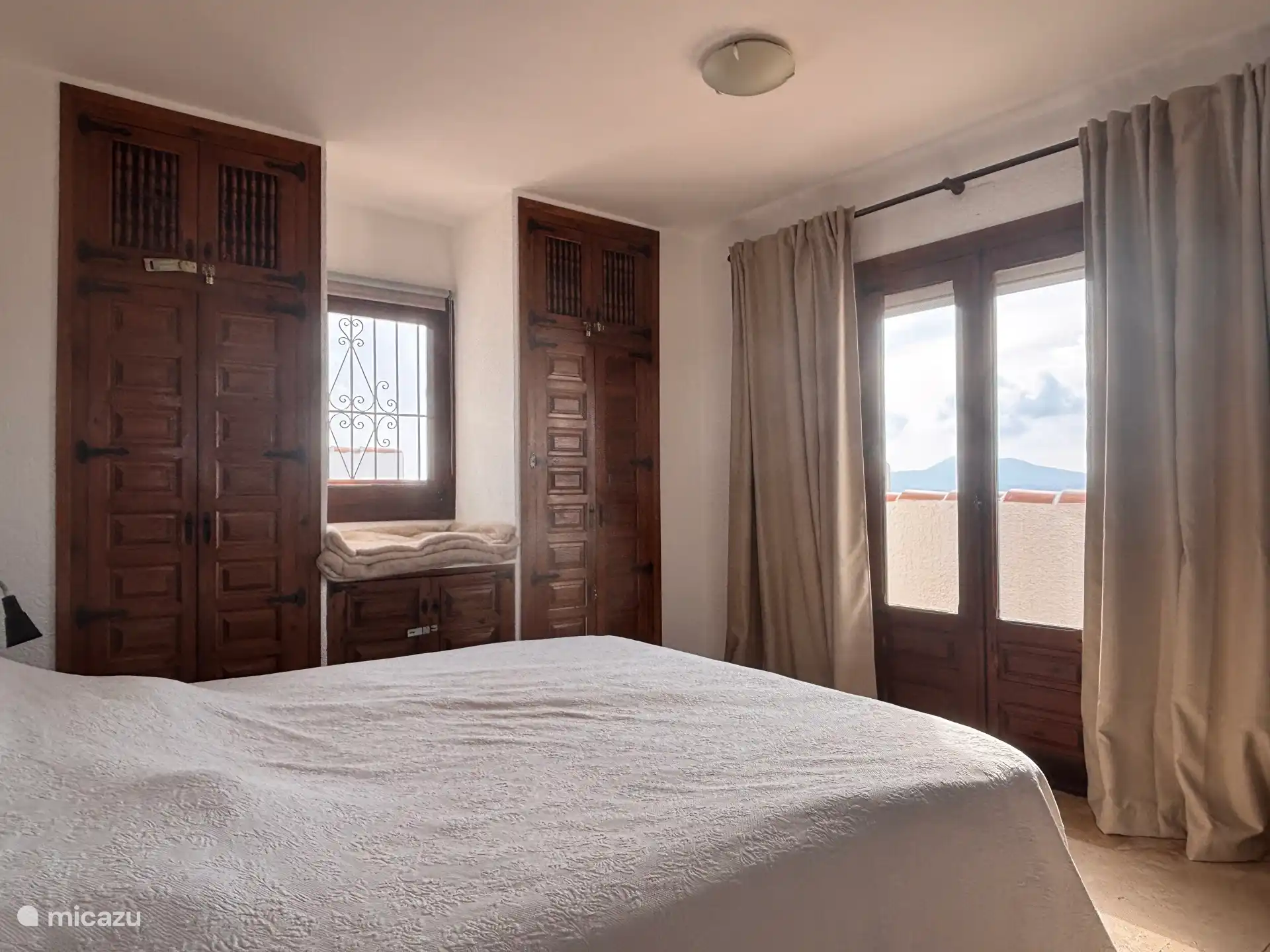 The upstairs bedroom with a large box spring mattress 200 by 180 cm, air conditioning and fitted wardrobes.