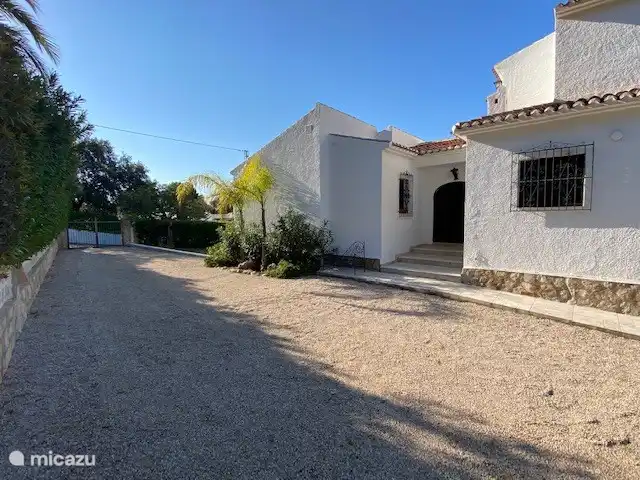 A photo of the house on the front door side, the walls were whitened again in 2022 and there is ample parking space.