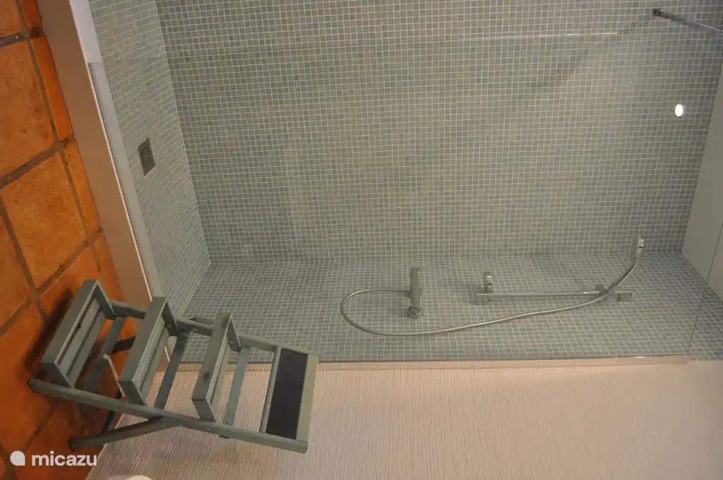 Baño en planta baja con ducha, WC y lavadora.