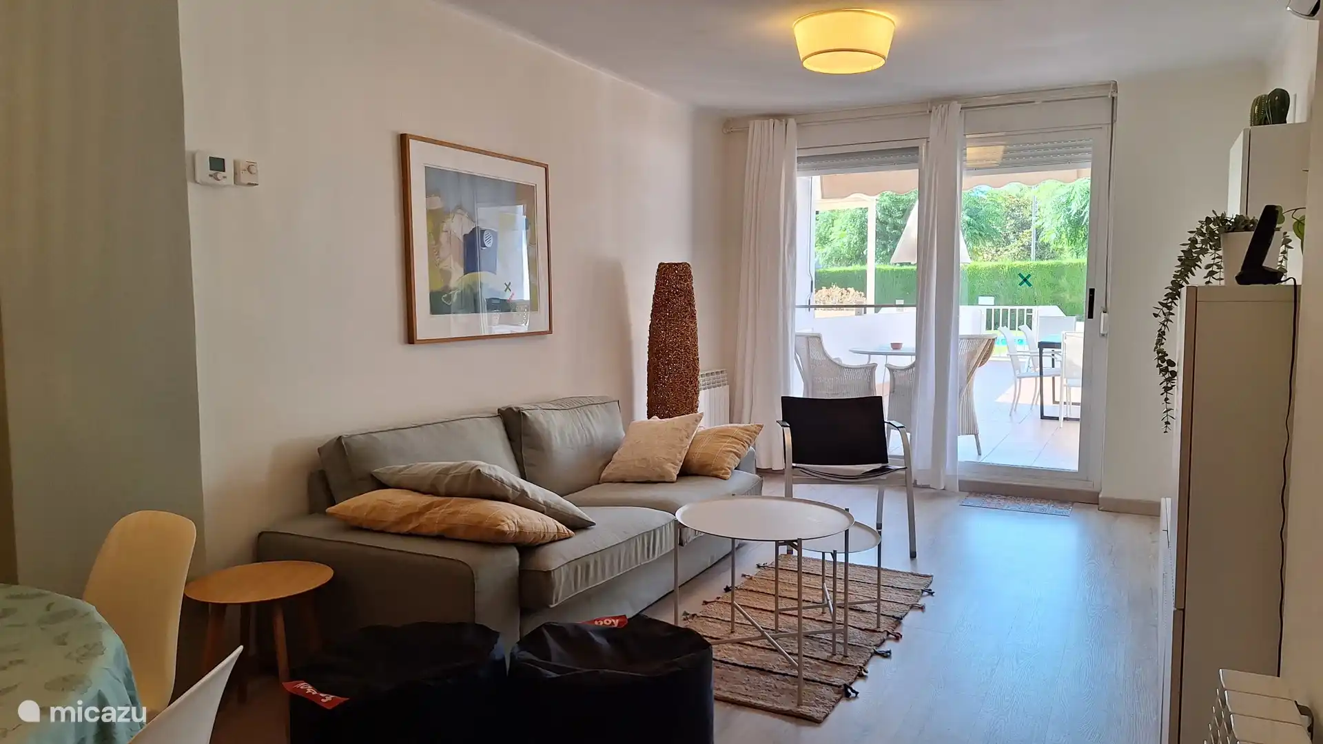 Woonkamer met eettafel voor 6 personen, zitgedeelte, airco en directe toegang tot het grote  privéterras. 