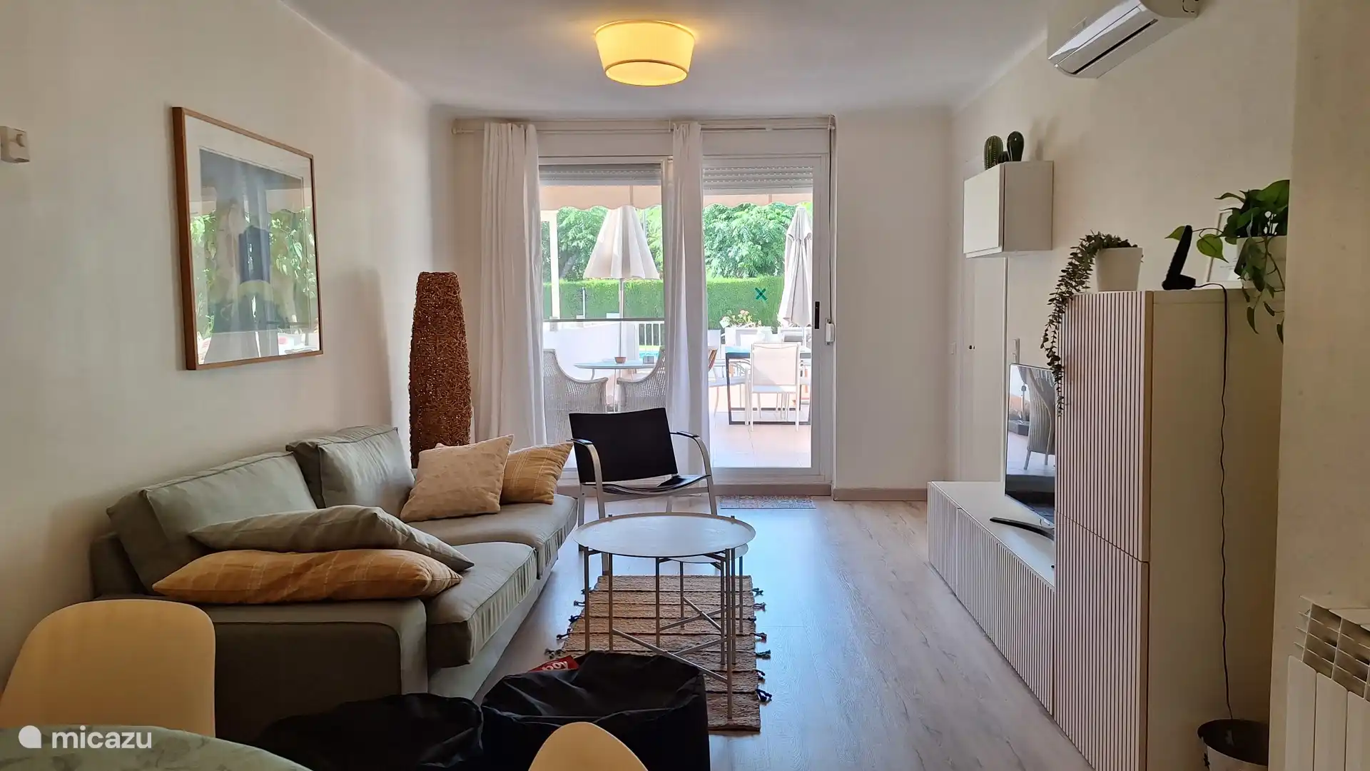 Woonkamer met eettafel voor 6 personen, zitgedeelte, airco, smartv en directe toegang tot het grote  privéterras. 