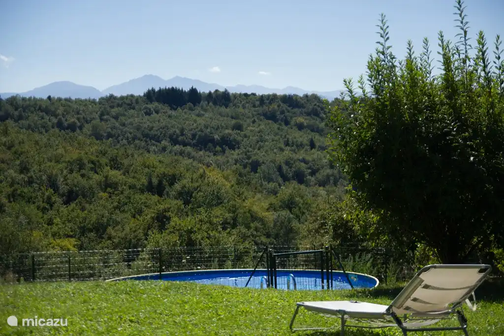 Das Schwimmbad befindet sich etwa zehn Meter von der Hütte entfernt, hinter den Bäumen