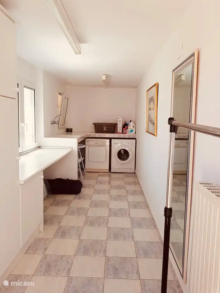 Ein separater Waschraum mit Waschmaschine, Trockner und Bügelbrett. Und auch 2 Kinderbetten und Hochstühle