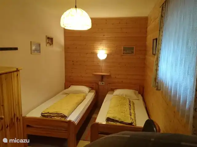 Q alm planta baja en Austria, Tirol, Maurach - chalet Dormitorio con dos camas y espacio para cama supletoria
