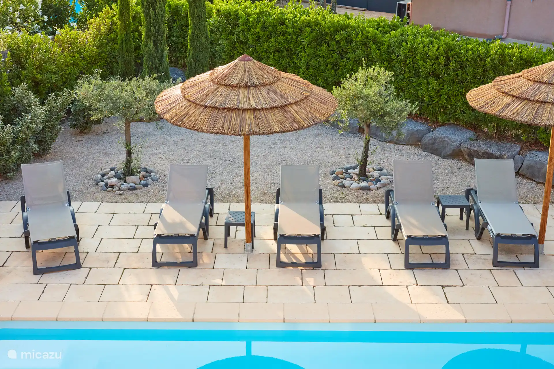 Terrasse rund um das Schwimmbecken mit 8 verstellbaren Sonnenliegen und festen Sonnenschirmen