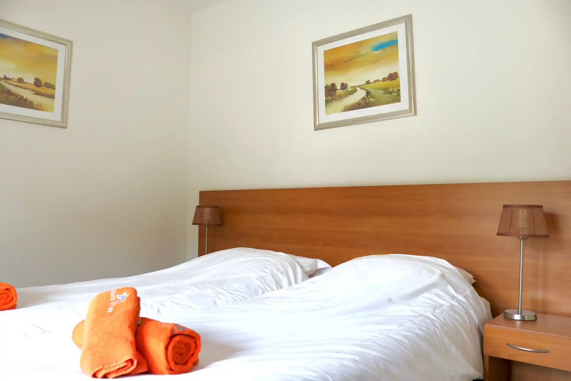 Slaapkamer beneden (voorzijde): boxspring, airco, plafondventilator, hordeur en luiken.