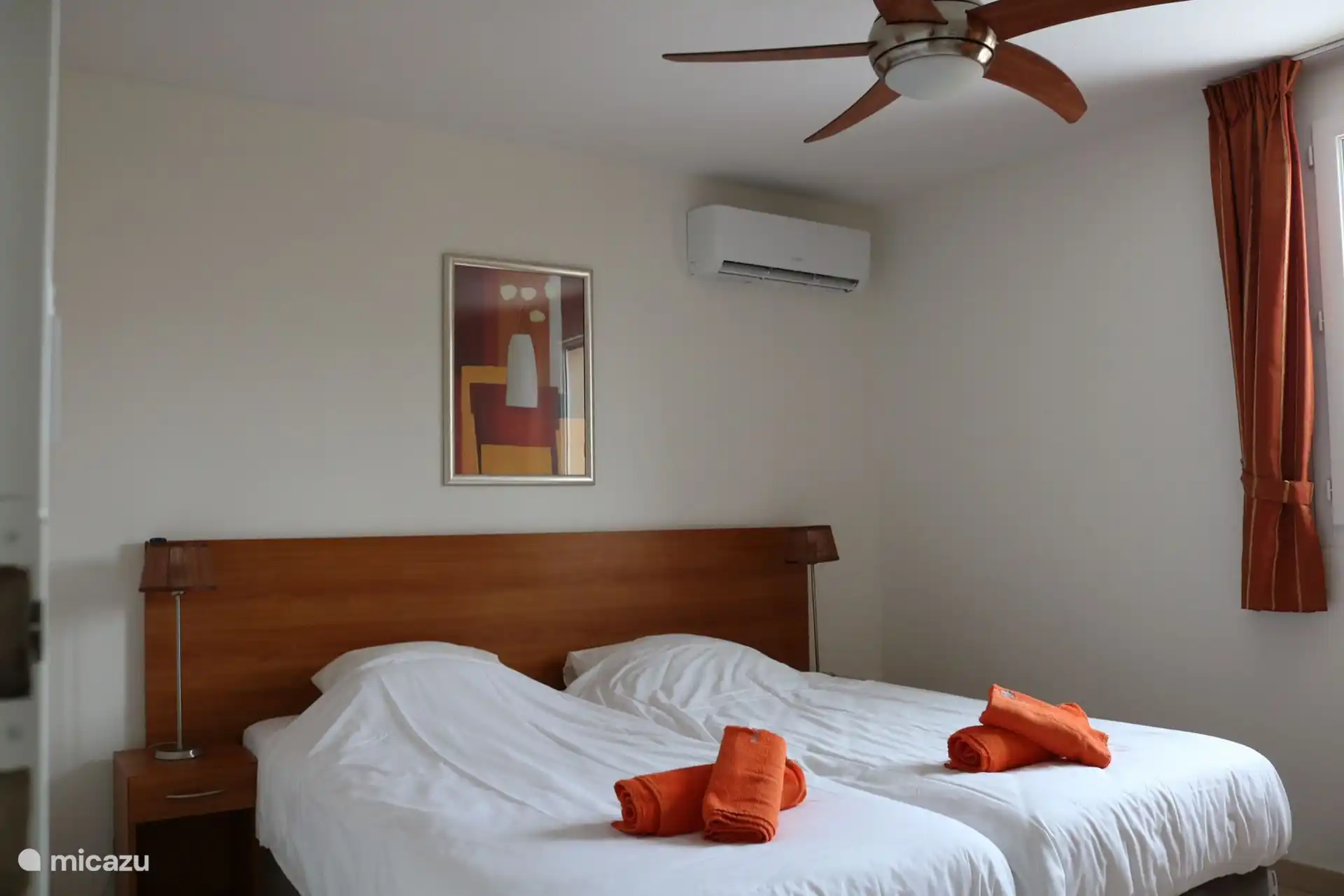 Slaapkamer boven (zwembadzijde): boxspring, airco, plafondventilator, rolhor en luiken.