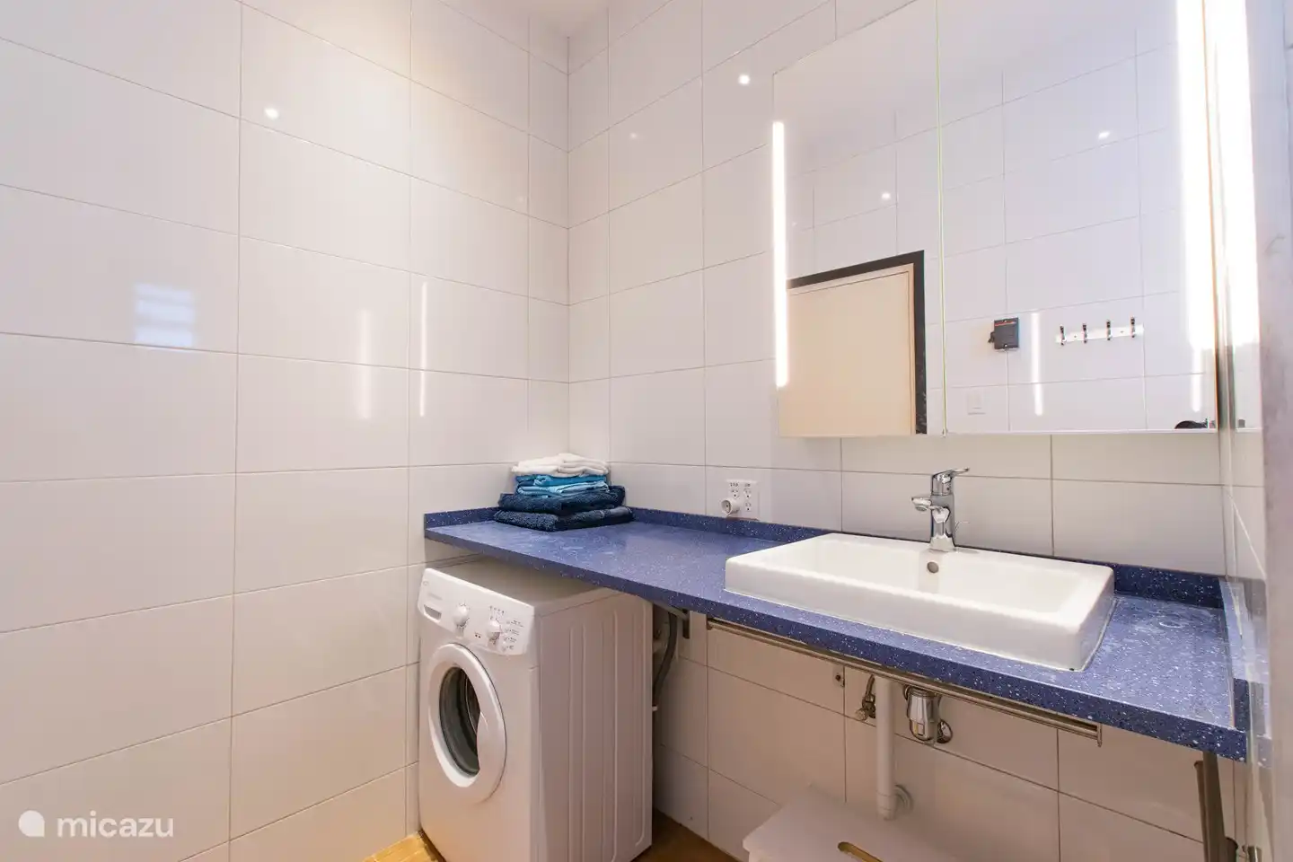 Waschbecken in einer großen Platte mit Spiegelschrank darüber.