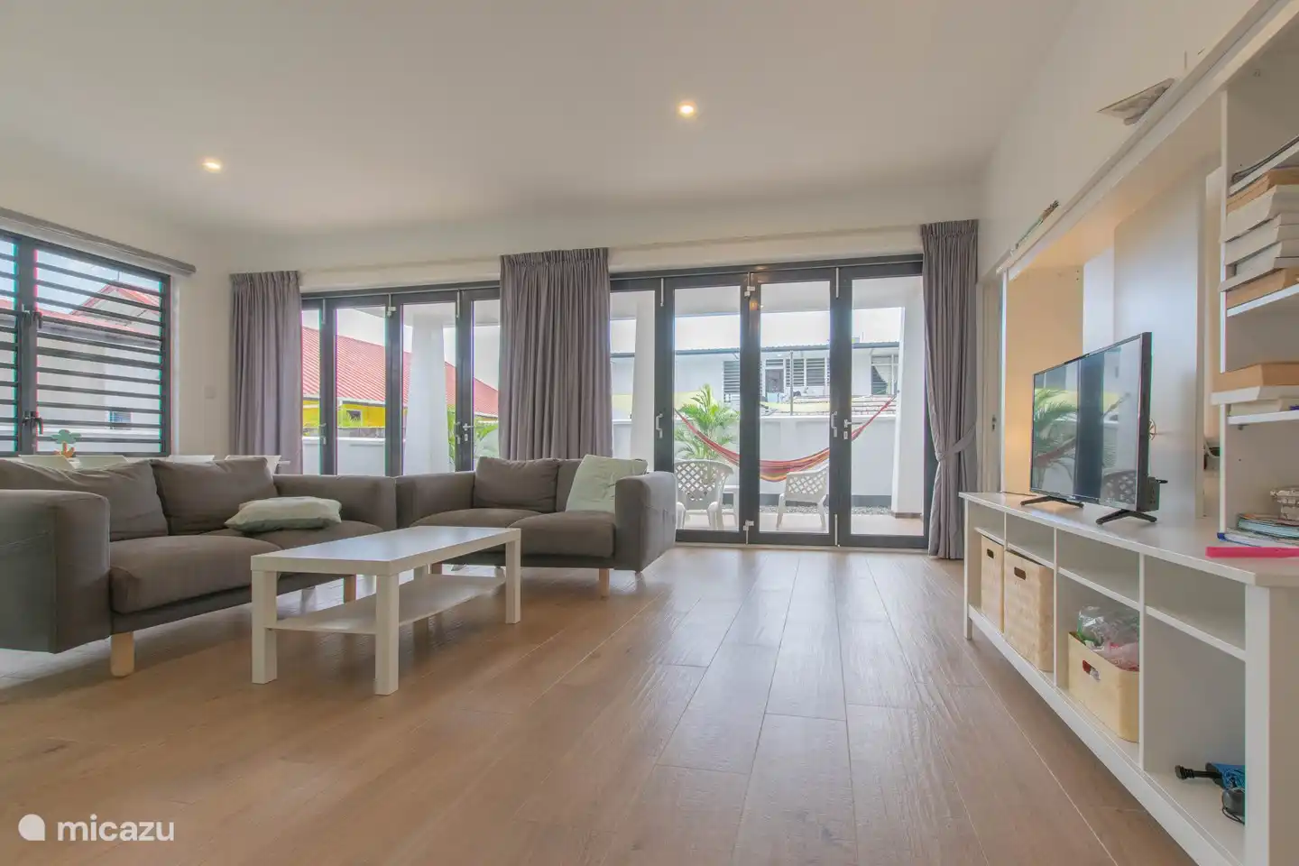 die Sitzecke mit Smart-TV und zwei großen Faltwänden nach draußen.