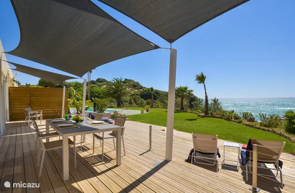 Holzterrasse mit Schatten und einem herrlichen Blick auf das Meer.