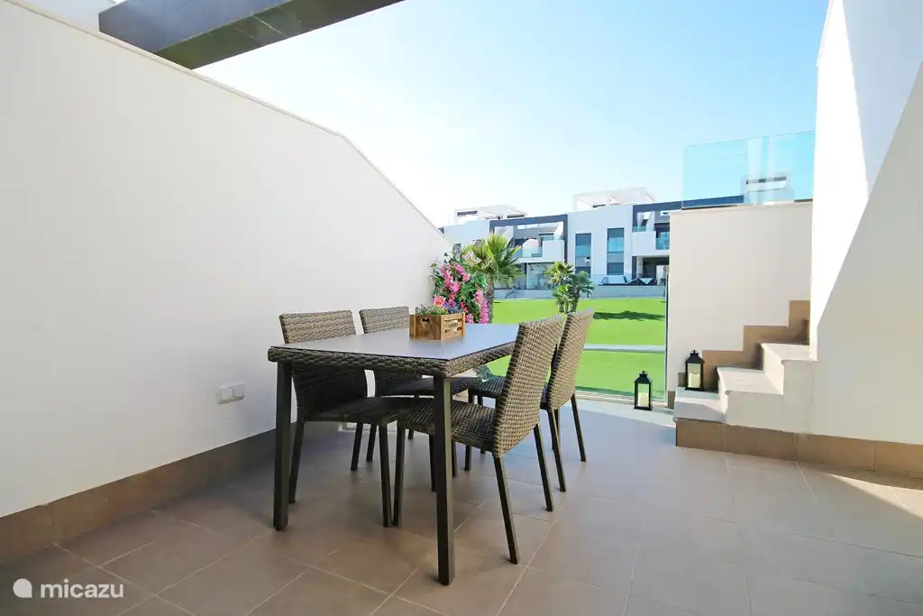 Balkon op het Zuidwesten met zonnescherm en uitzicht op tuin en zwembad.