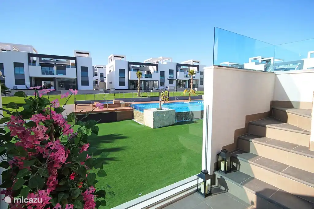 Balkon op het Zuidwesten met uitzicht over tuin en zwembad